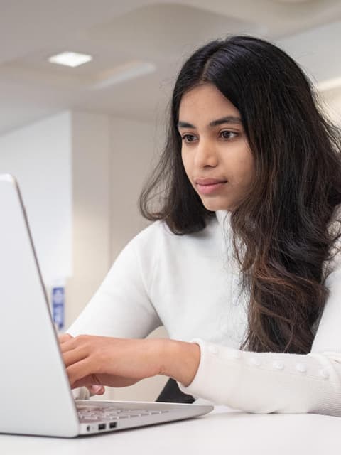 A student typing on a laptop.